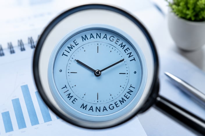Time management clock blue through a magnifying glass