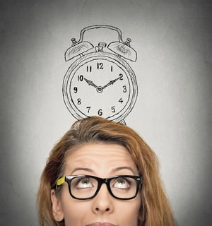 closeup headshot young business woman with alarm clock drawing sketch above her head, isolated grey wall background. Human face expressions, emotions. Time, punctuality, busy schedule concept